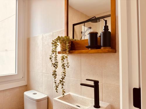 a bathroom with a toilet and a sink with a plant at Ola A Coruña in A Coruña
