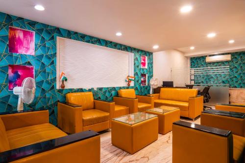 a waiting room with orange chairs and a large screen at Le Roi Jammu - Near Jammu Railway Station in Jammu