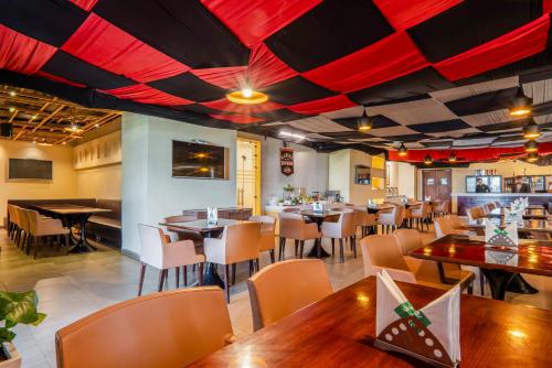 a restaurant with tables and chairs and red ceilings at Le Roi Jammu - Near Jammu Railway Station in Jammu