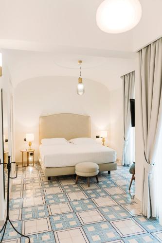 a bedroom with a white bed and a tiled floor at San Montano Resort & Spa in Ischia