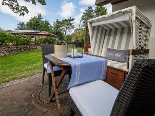 a patio with a table and chairs on a patio at Boutiquehotel Seiler Hof Keitum in Keitum