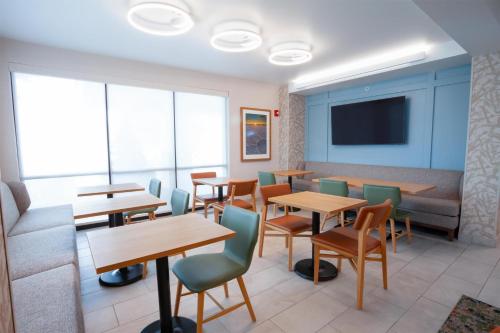 a waiting room with tables and chairs and a couch at Hampton Inn Salt Lake City-North in Woods Cross