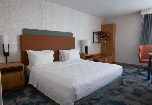 a hotel room with a large bed and a chair at Hampton Inn Salt Lake City-North in Woods Cross