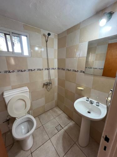 a bathroom with a toilet and a sink at Cabaña brisas del lago in Villa Parque Siquiman