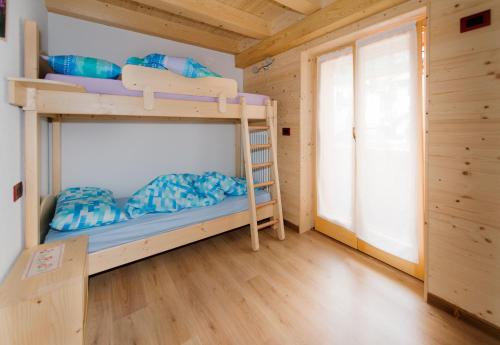 a bedroom with bunk beds in a wooden cabin at Albergo Diffuso Dolomiti in Forni di Sotto