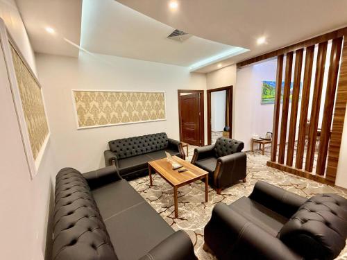 a living room with two couches and a table and chairs at Sheek Hotel in Erbil
