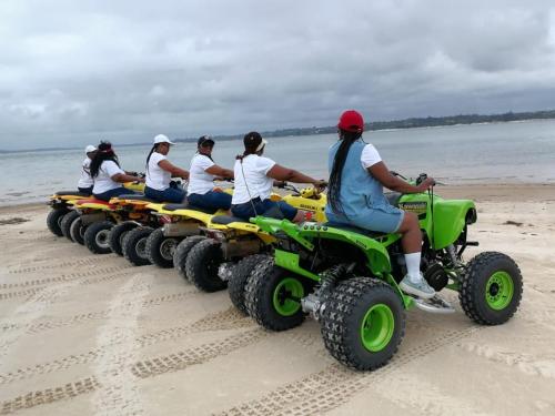 a group of women riding on atvs on the beach at Blackstone Sands Resort Bilene in Vila Praia Do Bilene