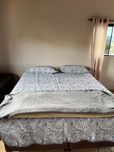 a bed with a blue blanket and pillows on it at Estalagem Setani in Cunha