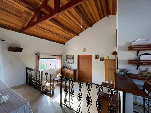 a living room with a wooden ceiling and a staircase at Estalagem Setani in Cunha