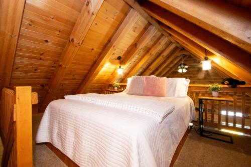 a bedroom with a white bed in an attic at Honey Bear Cabin in Millersburg