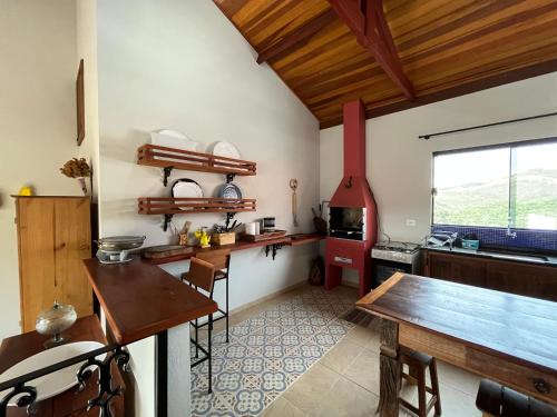 a kitchen with a wooden table and a stove at Estalagem Setani in Cunha