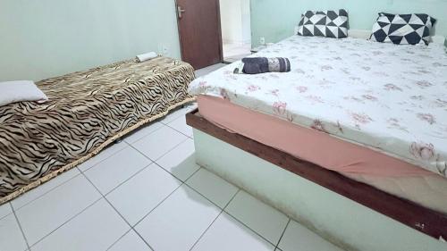 a bedroom with two beds and a tiled floor at Beach house in Búzios with pool in Nísia Floresta