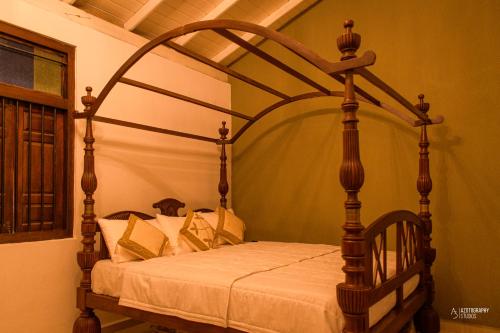 a wooden canopy bed in a room at Seaside 3BR AC Villa with Private Pool in Ambalangoda