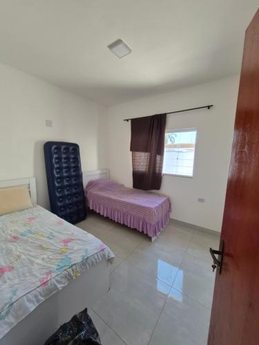 Ένα ή περισσότερα κρεβάτια σε δωμάτιο στο Casa com piscina e espaço churrasco Itanhaem