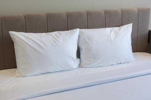 two white pillows sitting on top of a bed at Sam Hotel & Apartment Da Nang in Da Nang
