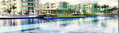 a large body of water in front of a building at Porto de Galinha Muro Alto Flat in Ipojuca