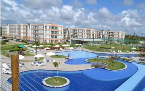 a resort with a large pool with chairs and umbrellas at Porto de Galinha Muro Alto Flat in Ipojuca