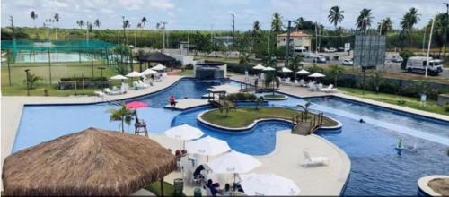 a large swimming pool in a resort with a water park at Porto de Galinha Muro Alto Flat in Ipojuca