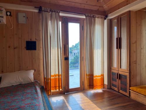 a bedroom with a bed and a sliding glass door at Rimil Homestay Santiniketan in Shānti Niketan