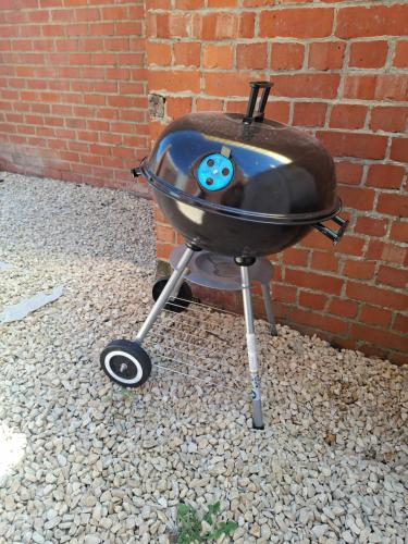 a bbq grill sitting next to a brick wall at Au Paon Dort in Cambron-Casteau