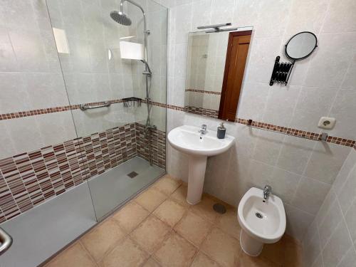 a bathroom with a sink and a shower and a toilet at Anahi Home Corralejo - Villa Cardon 12 in La Oliva