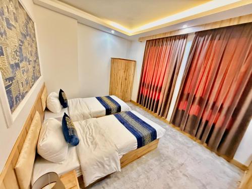 a bedroom with a bed and a large window at Sheek Hotel in Erbil