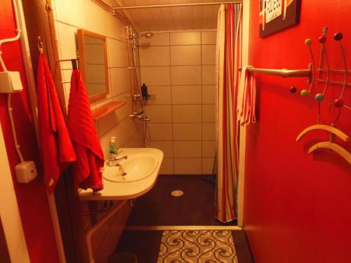 a bathroom with a white sink and a red shower at Gula Villan in Maxmo