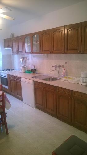a kitchen with wooden cabinets and a sink at J&B Holiday House Hvar in Hvar