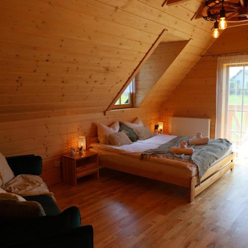 een slaapkamer met een bed in een blokhut bij Leśny Zakątek Zawoja in Stryszawa