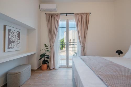 a bedroom with a bed and a sliding glass door at Porto Blu - Sea View Apartment in Kos Town