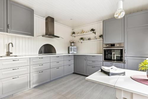 a kitchen with white cabinets and silver appliances at Spacious 3-Bedroom Apartment with Balcony and Free Parking Orkland near Trondheim in Fannrem