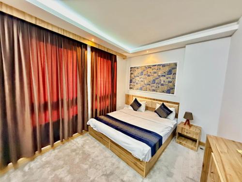 a bedroom with a bed and a large window at Sheek Hotel in Erbil