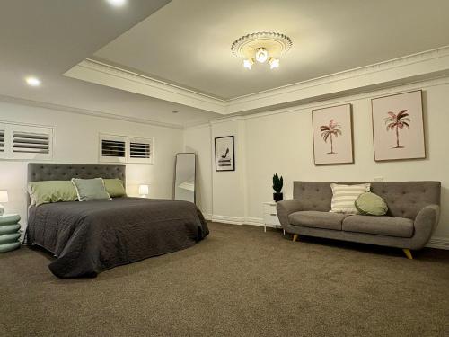 a bedroom with a bed and a couch at 'Bellevue Manor' on Beauty Point in Wagga Wagga
