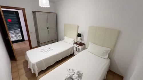 ein Hotelzimmer mit zwei Betten und einem Spiegel in der Unterkunft Anahi Homes Corralejo- Dracaena 20 in La Oliva