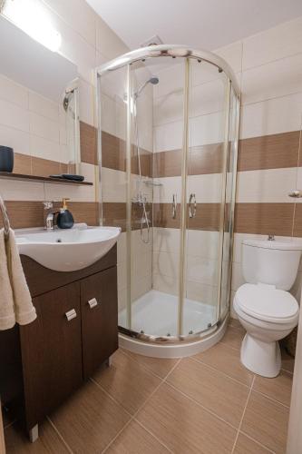 a bathroom with a shower and a toilet and a sink at Porto Blu - Sea View Apartment in Kos