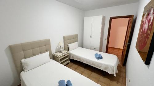 a small room with two beds and a mirror at Anahi Homes Corralejo - Villa Drago 12 in La Oliva