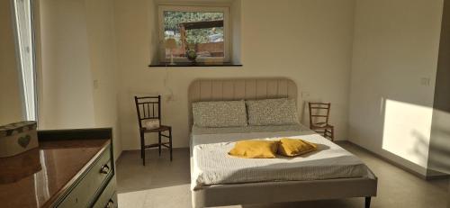 1 dormitorio con 1 cama con 2 almohadas amarillas en Villa Razeto, en Zoagli