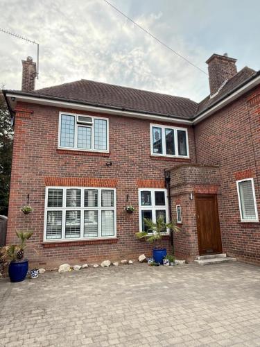 a brick house with white windows and a door at Spacious 6 Bedroom house, Luton in Luton