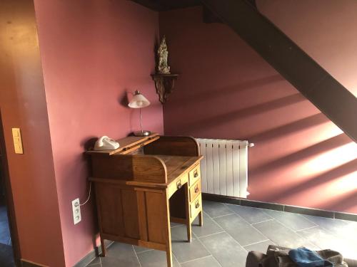 a room with a desk with a lamp on a wall at la Cure in Meslin-lʼÉvêque