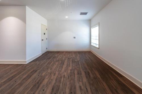 an empty room with white walls and wood floors at SpringBrook Lofts in Alcoa