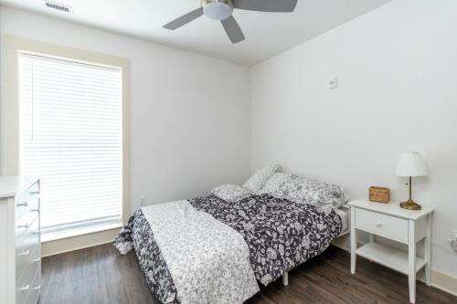 a white bedroom with a bed and a ceiling fan at SpringBrook Lofts in Alcoa