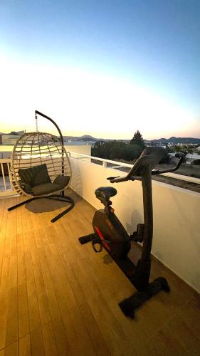 a balcony with a helicopter and a chair on a roof at Euphoria Luxury apartment in Faliraki