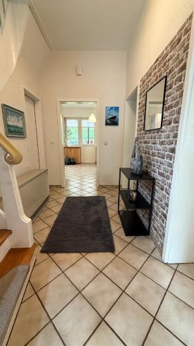 a hallway with a tile floor and a brick wall at Cozy House in Pulheim