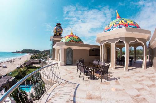 a villa with a patio with a table and chairs at Dharma Beach in Montañita