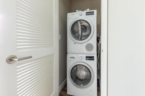 a laundry room with a washer and dryer next to a door at Private 2BR Apt Seaport Disctrict in Boston