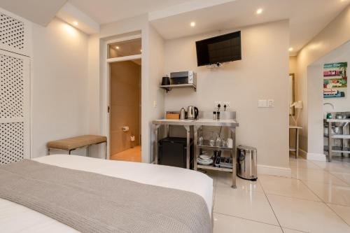 a bedroom with a bed and a tv on the wall at Camps Bay Village in Cape Town