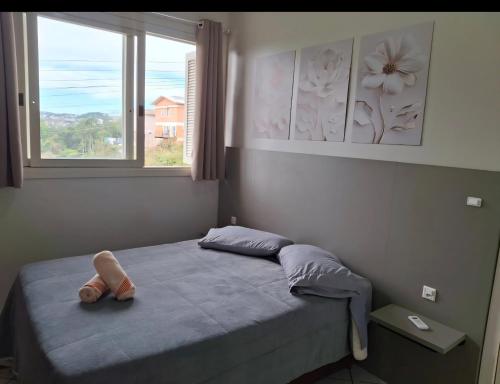 a bedroom with a bed with a shoe on it at Ap Cabernet 2 in Bento Gonçalves