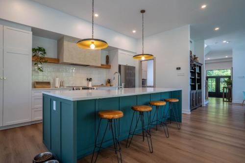 a kitchen with a blue island with bar stools at Spa Pool table Lake access - Le 515 Beaulac in Chertsey