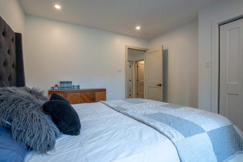 a bedroom with a bed with blue pillows on it at Spa Pool table Lake access - Le 515 Beaulac in Chertsey