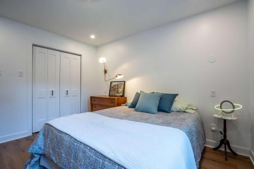 a bedroom with a large bed with blue pillows at Spa Pool table Lake access - Le 515 Beaulac in Chertsey